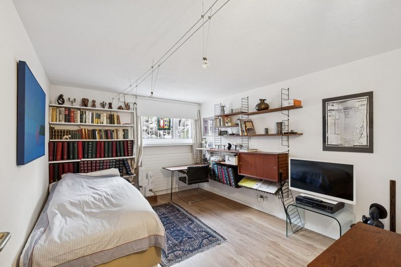 Helles Zimmer mit Bett, Bücherregal und Arbeitsplatz im Einfamilienhaus in Zofingen
