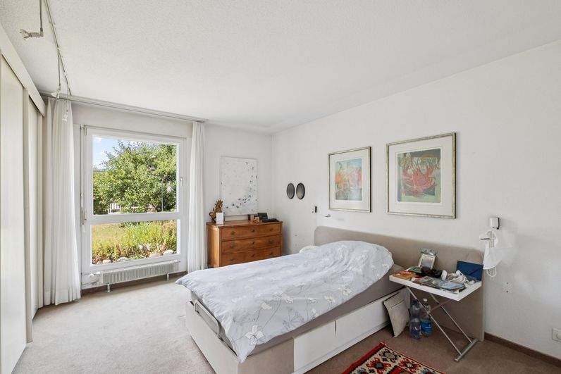 Helles Schlafzimmer mit grossem Fenster und Blick in den Garten in Zofingen